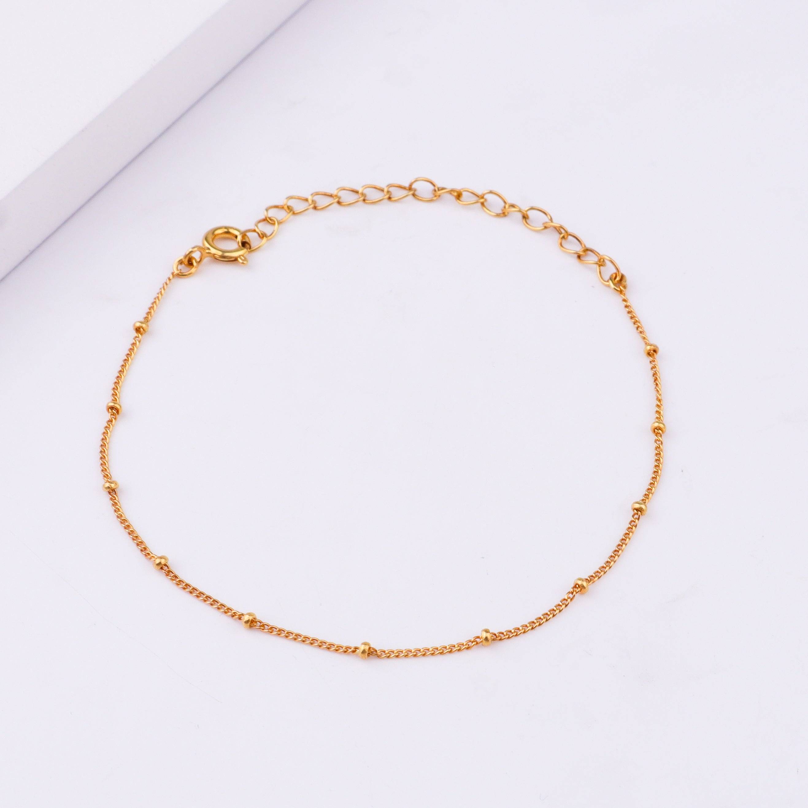Gold chain bracelet on white background