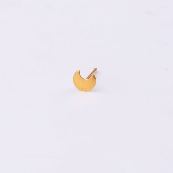 Close-up of gold-tone crescent moon nose pin on white surface