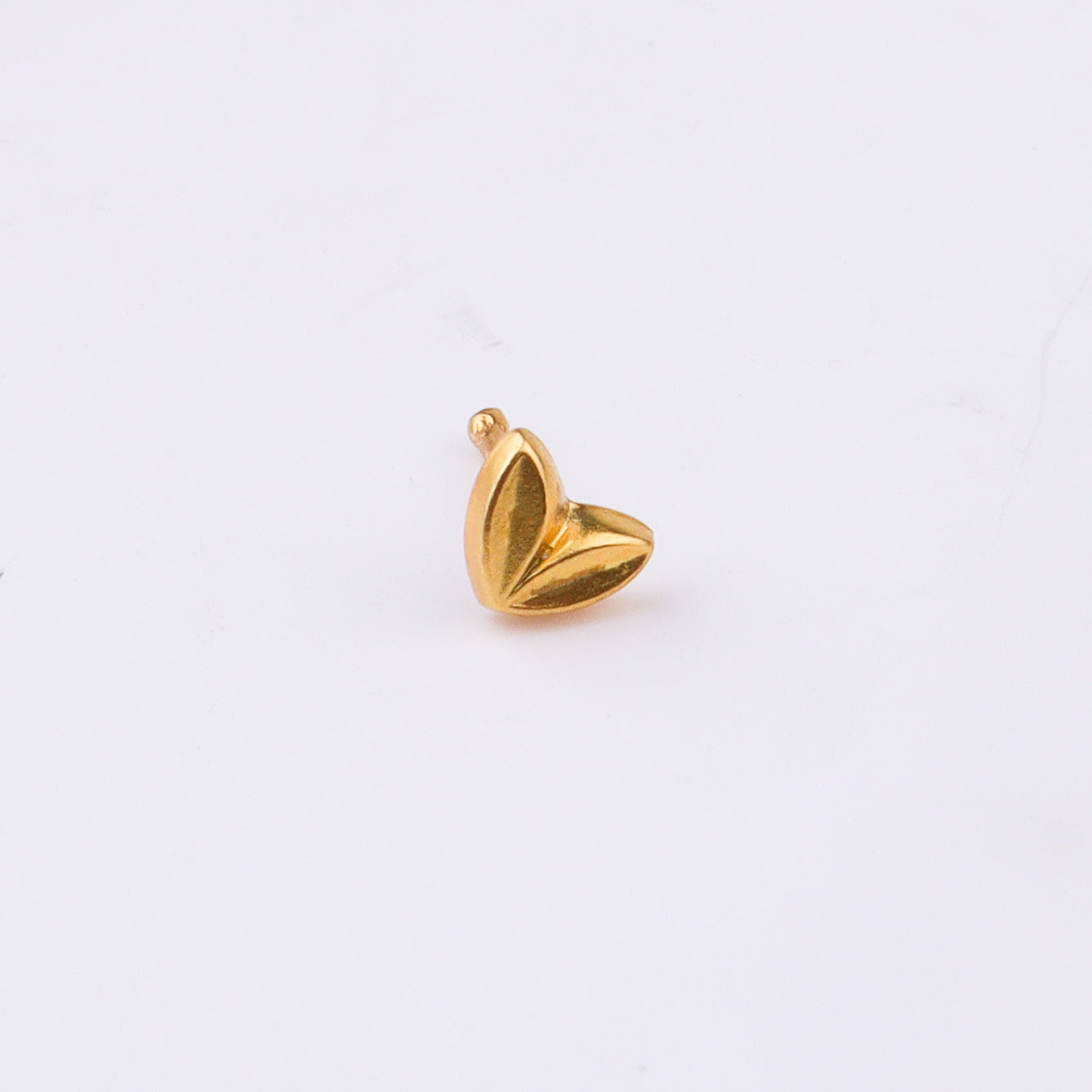 Gold heart nose pin with backing on white background