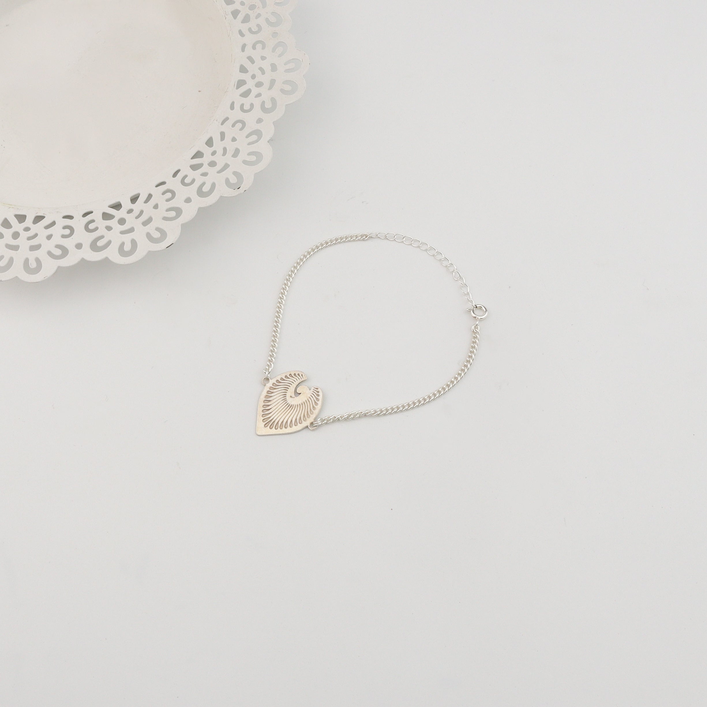 Detail shot of peacock feather motif in sterling silver