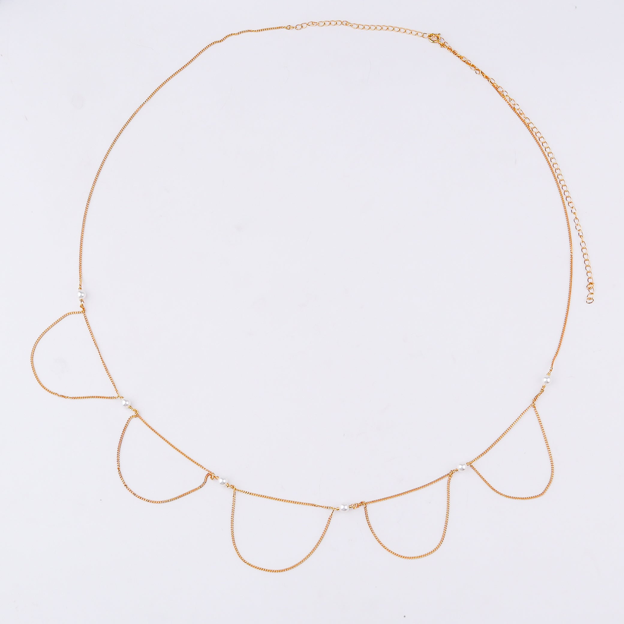 Elegant gold waist chain with pearl accents on white background