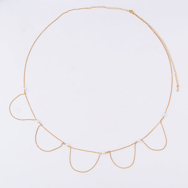 Elegant gold waist chain with pearl accents on white background