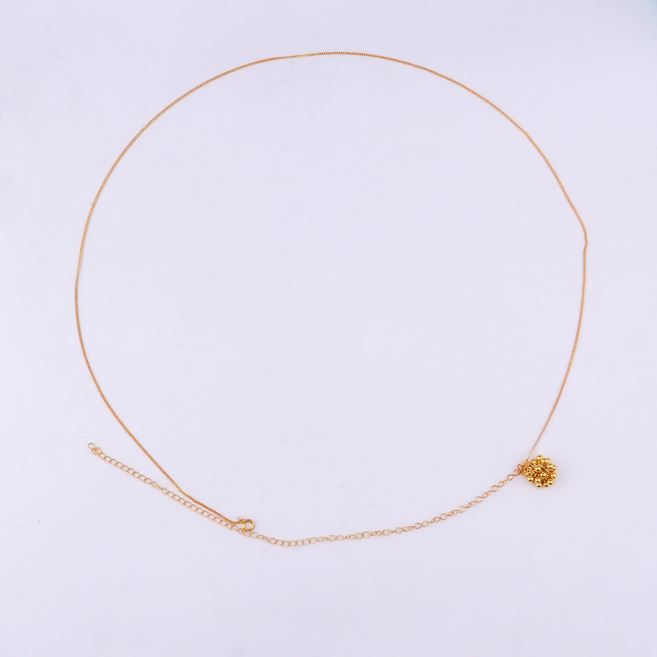 Gold chain with floral pendant on white background
