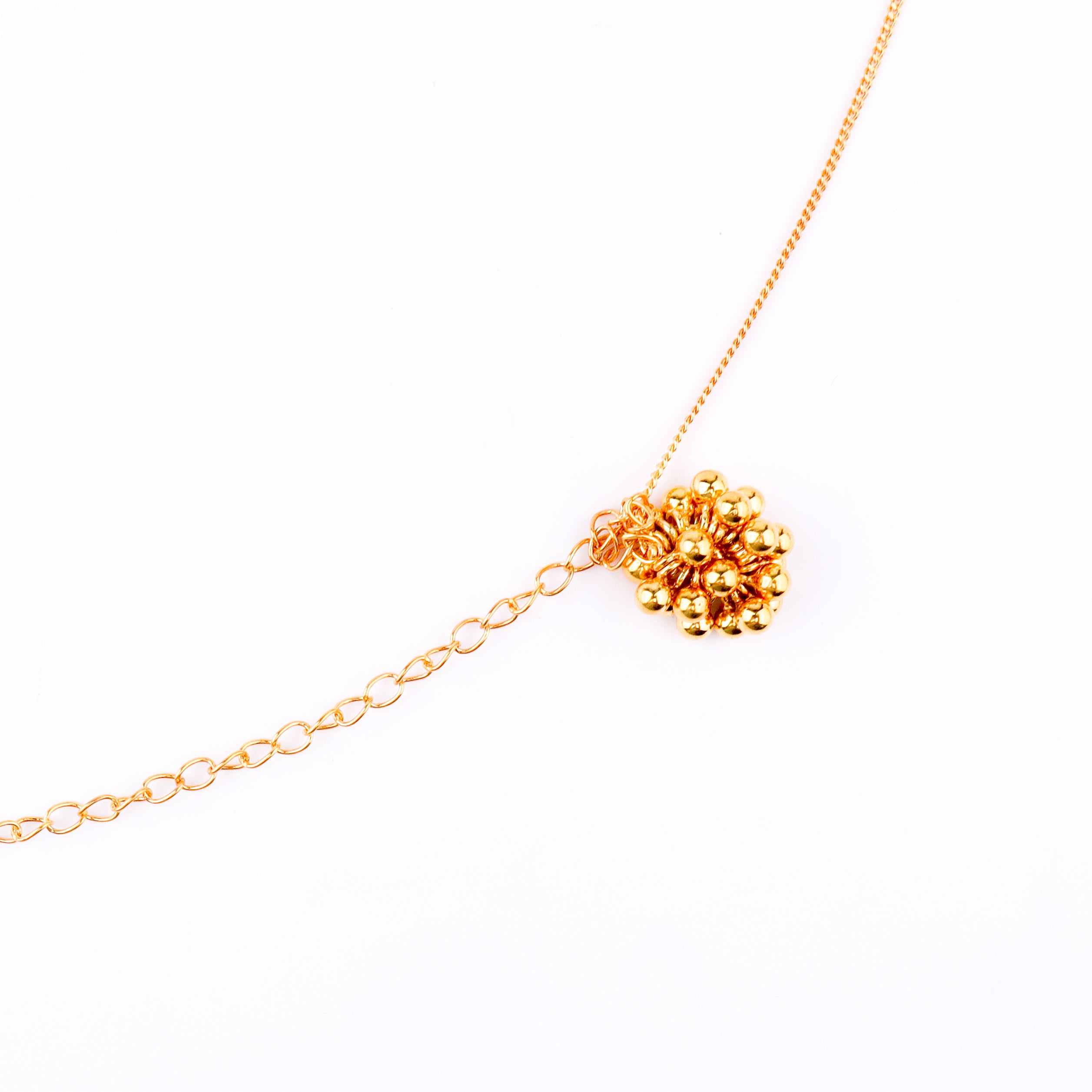 Gold chain with floral pendant on white background