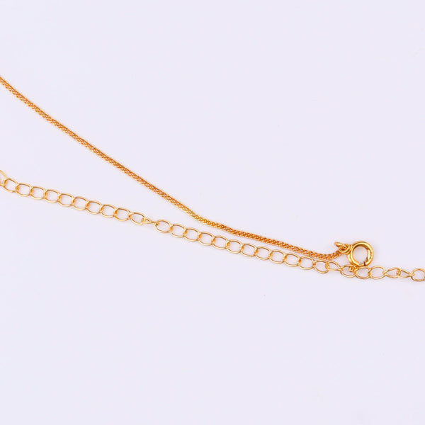 Gold chain with floral pendant on white background