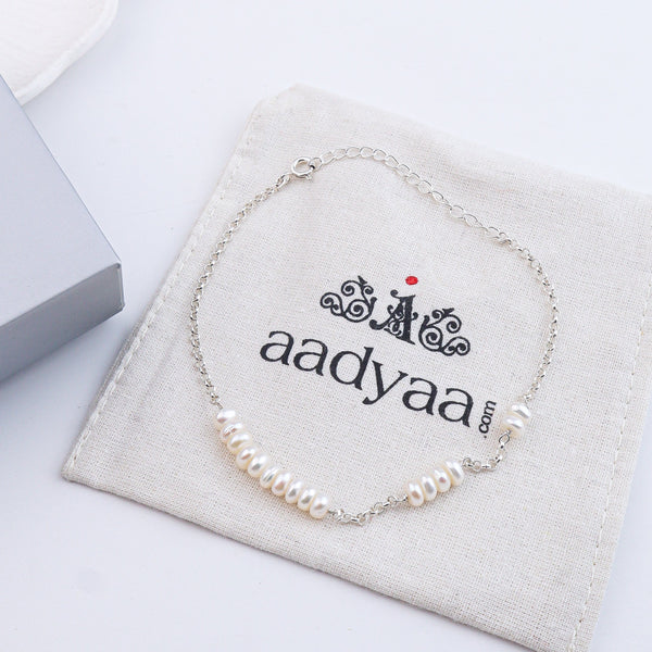 Pearl silver anklet on white fabric