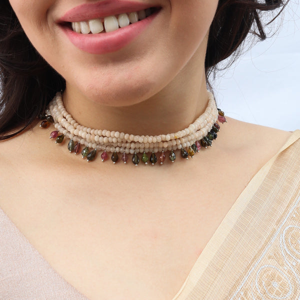 Woman wearing beaded jewelry with pearls and gemstones