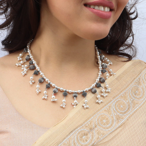 Close-up of pearl and oxidized bead necklace on model