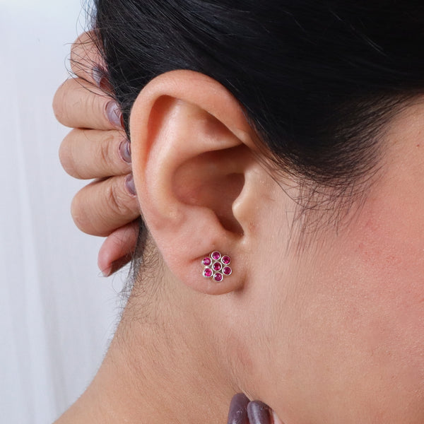 Close-up of pink gemstone earrings worn on ear