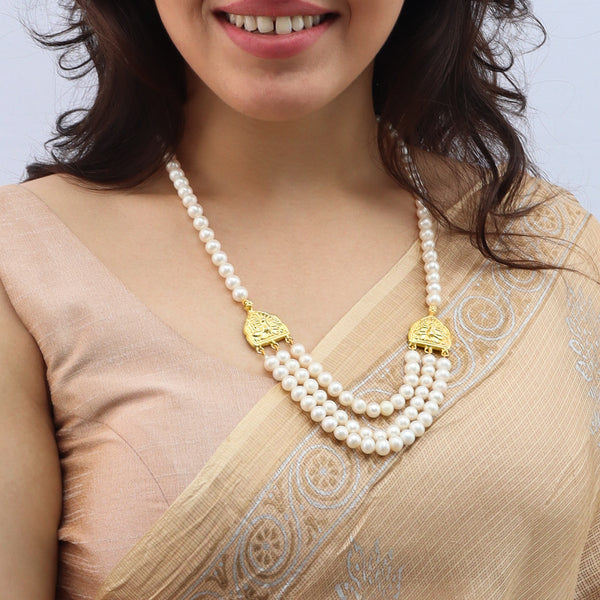 Woman wearing pearl necklace with gold details and traditional attire