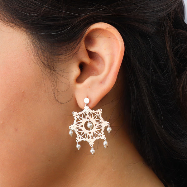 Close-up of silver filigree earrings on white background