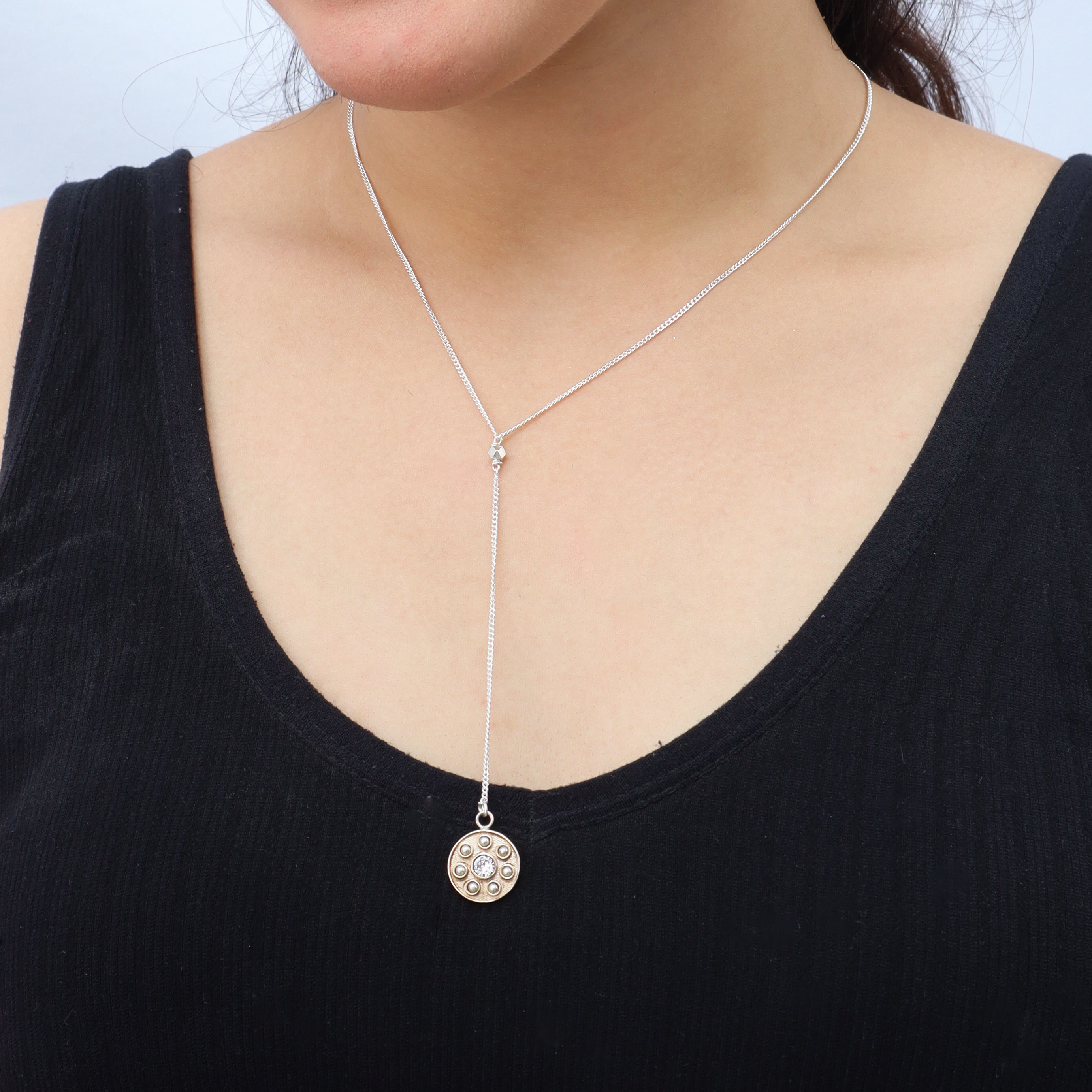 Detail shot highlighting polished silver chain and pendant