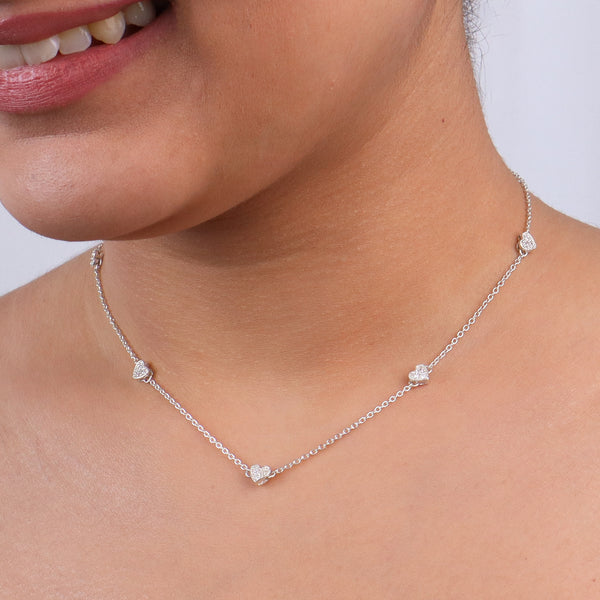 Silver heart necklace with CZ accents on a woman's neck
