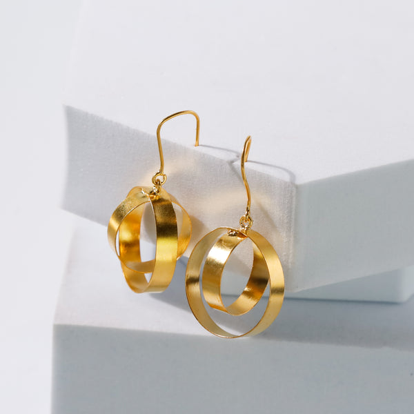Gold earrings displayed on a white surface