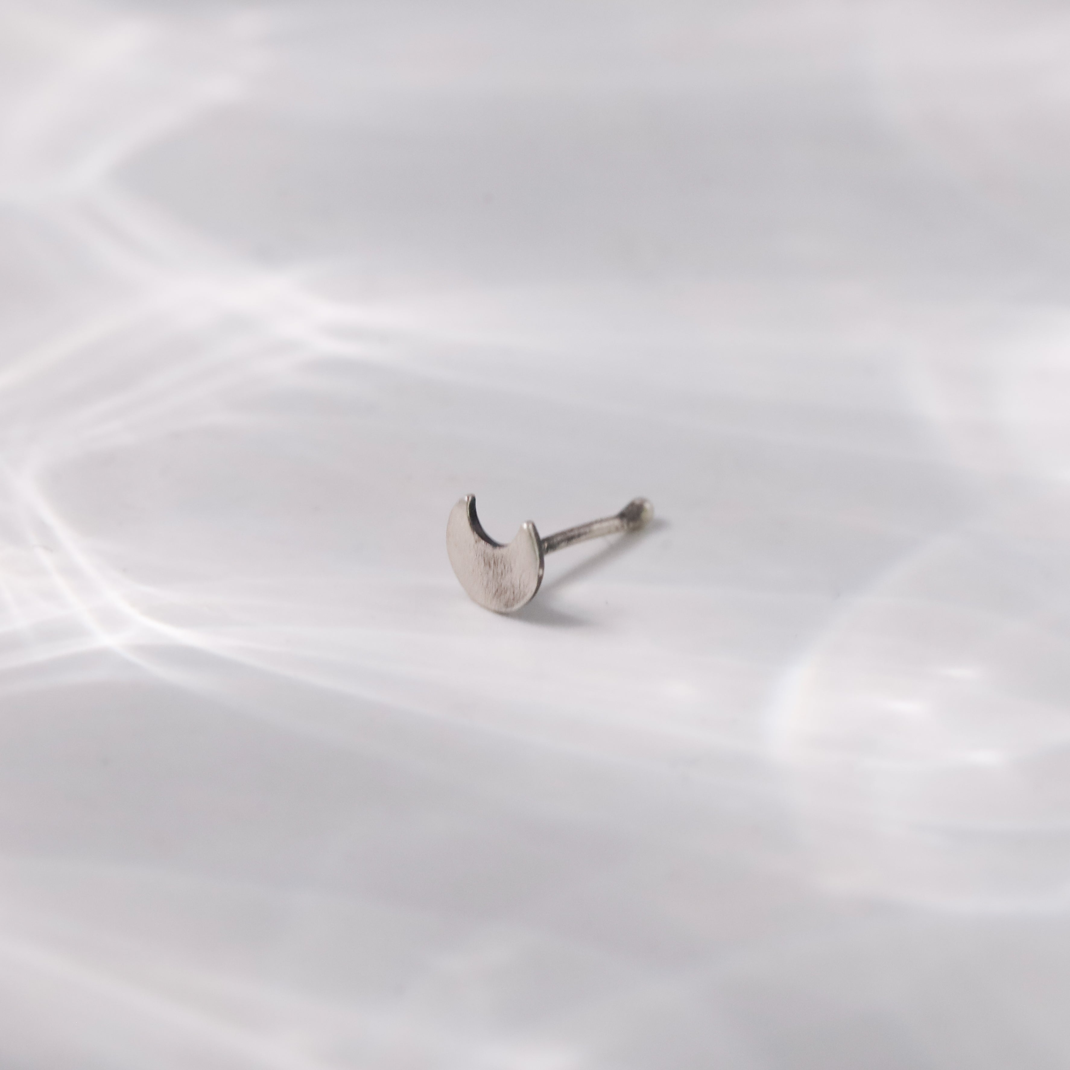 Angled side view of Silver Tiny Chandrakor Nose Pin