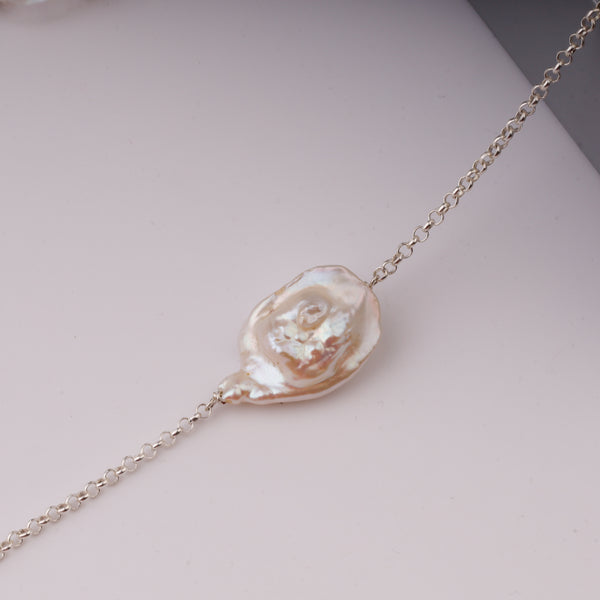 Pearl and silver chain jewelry on black stand