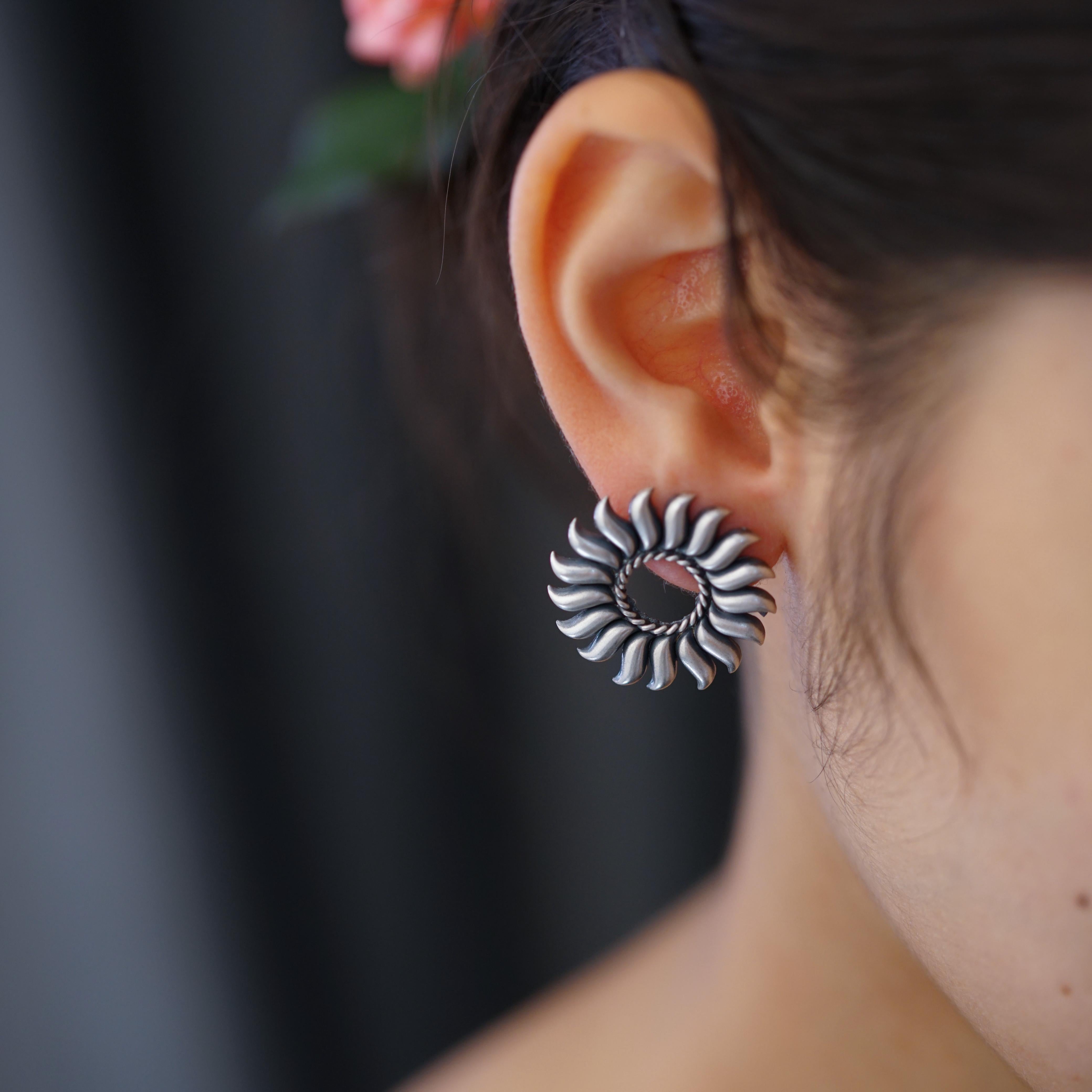 a close up of a person wearing a pair of earrings