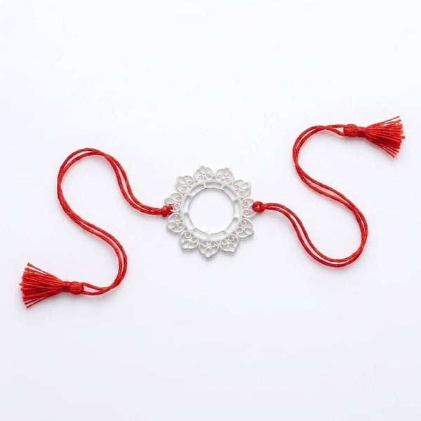 Flat-lay of Big Filigree Silver Rakhi with festive décor, gift box, and Raksha Bandhan essentials