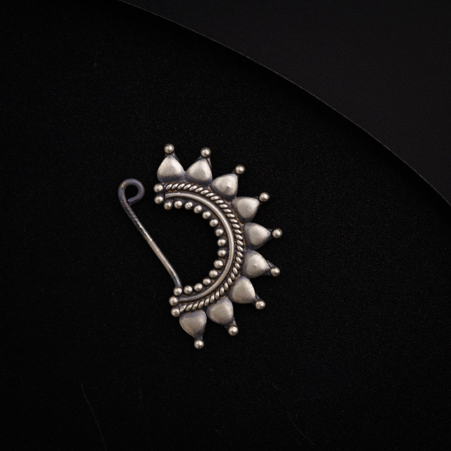 a close up of a brooch on a black surface