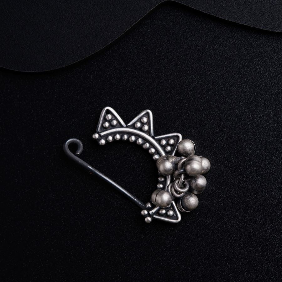 a silver brooch with beads and a cat on it