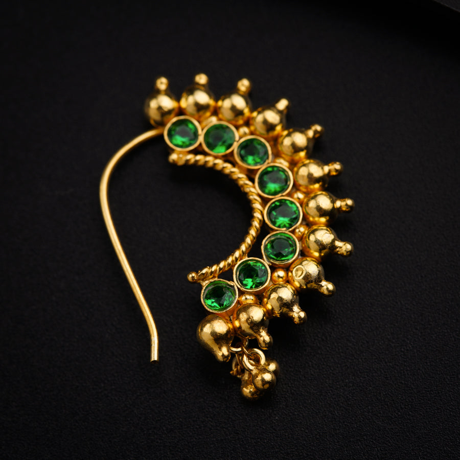 a close up of a green and gold brooch
