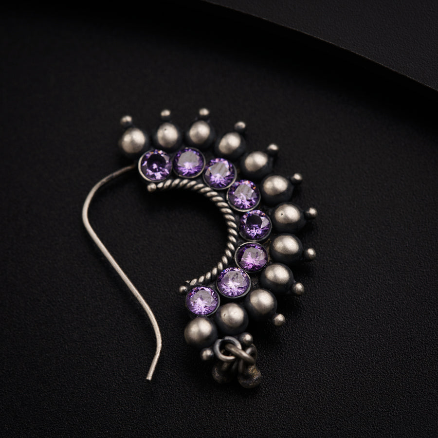 a close up of a purple and silver brooch