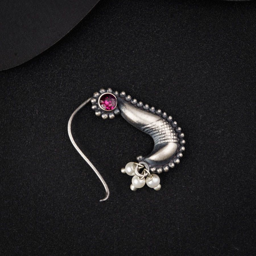 a silver brooch with a pink stone on it