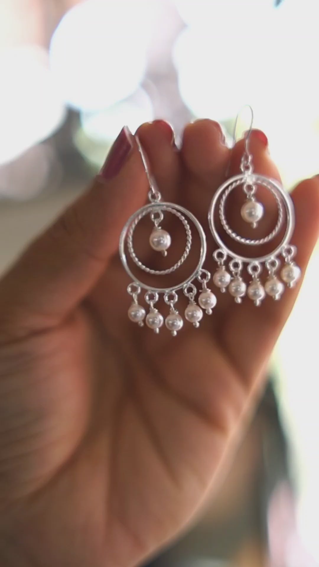 a person holding a pair of earrings in their hand