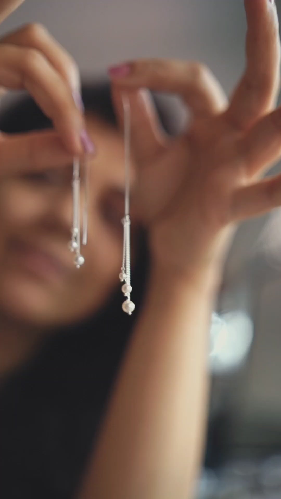 a close up of a person holding a pair of earrings