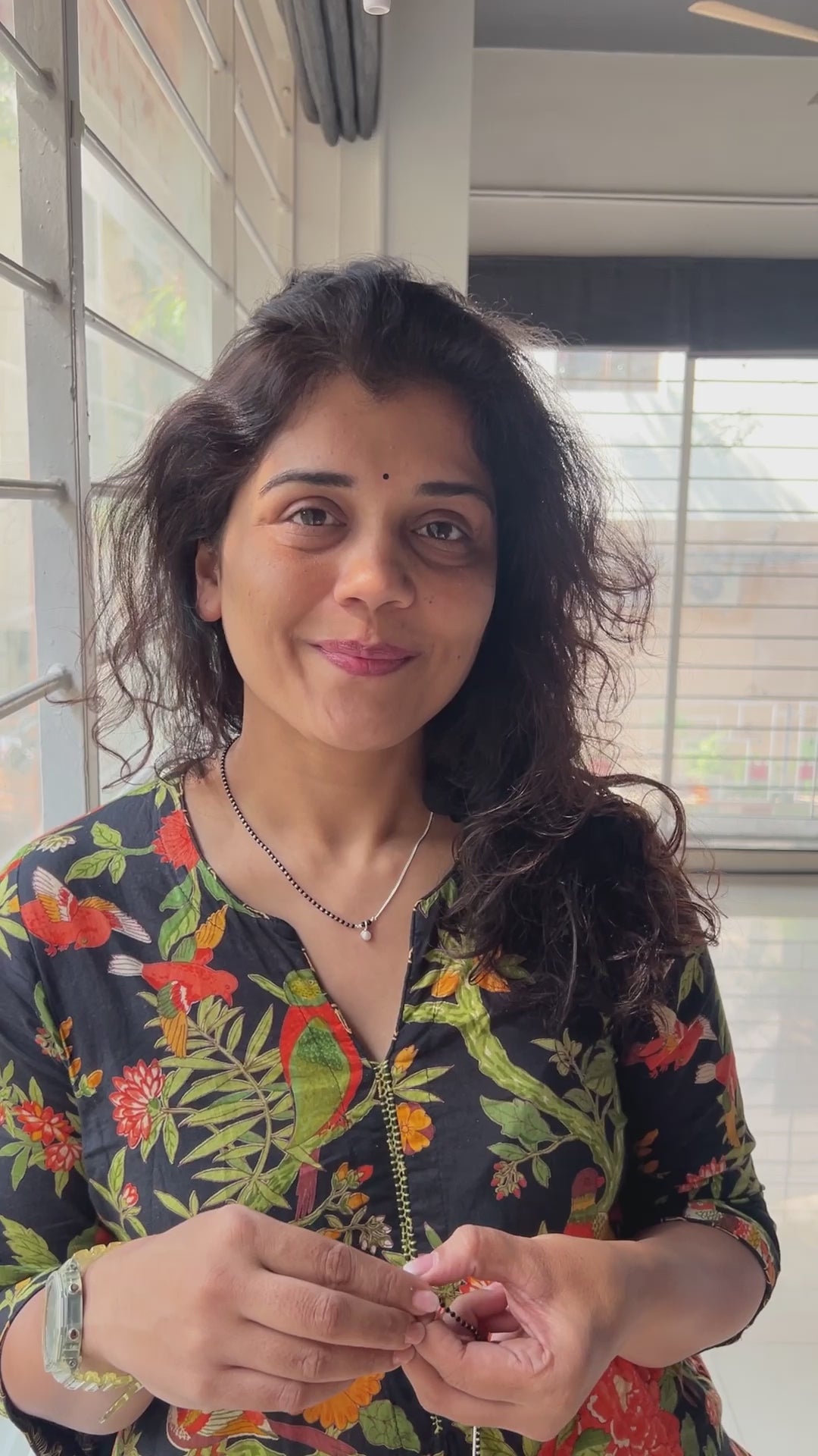 a woman standing in front of a window holding a piece of food