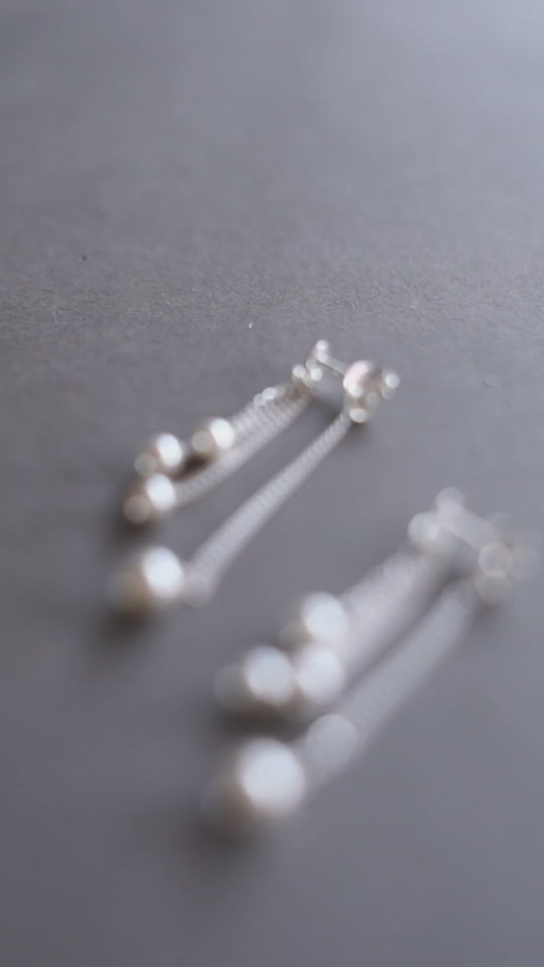 a pair of earrings with pearls on them