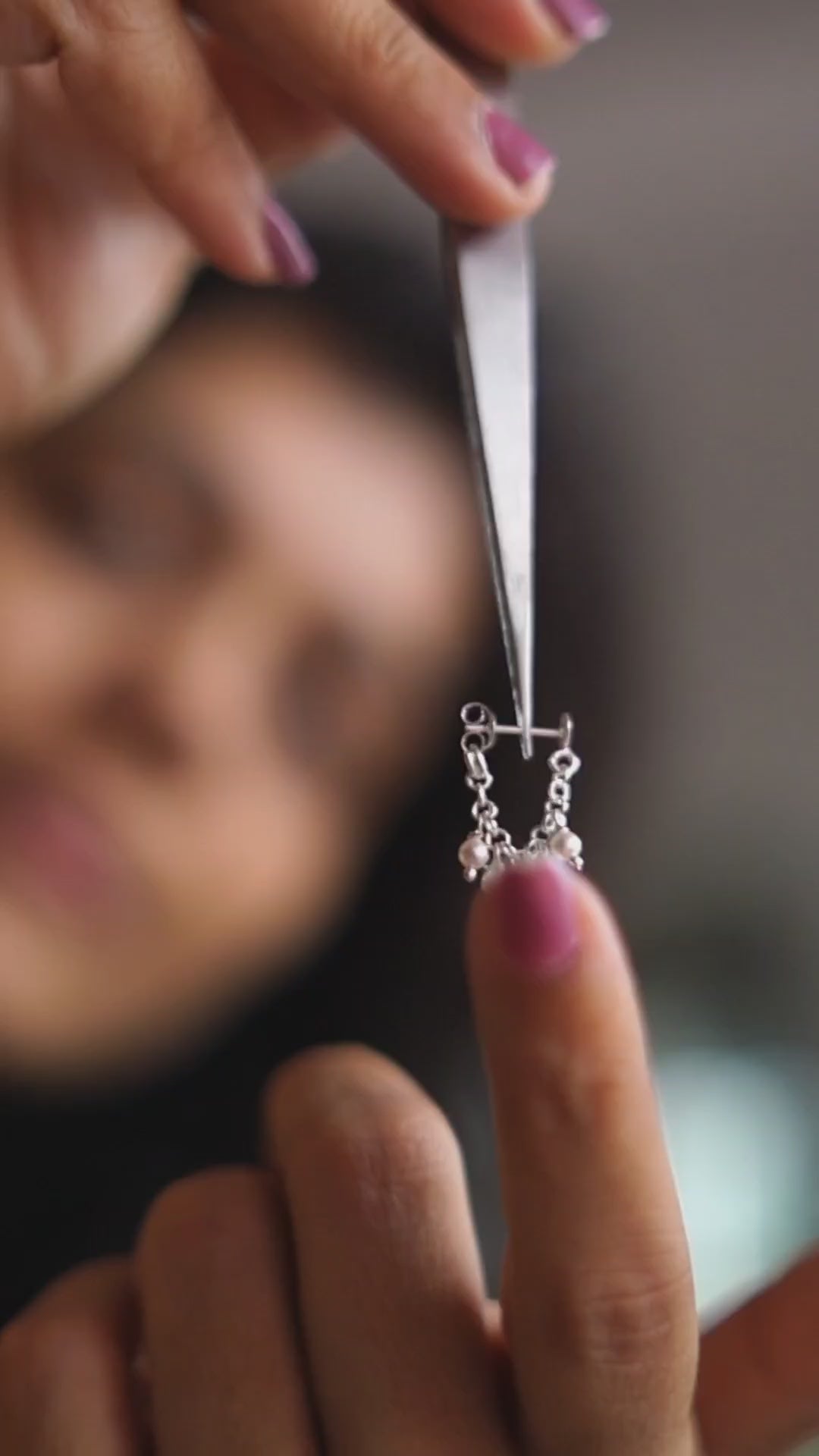 a woman holding a piece of jewelry in her hand