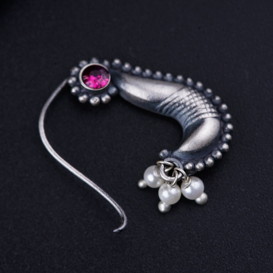 a close up of a brooch on a black surface