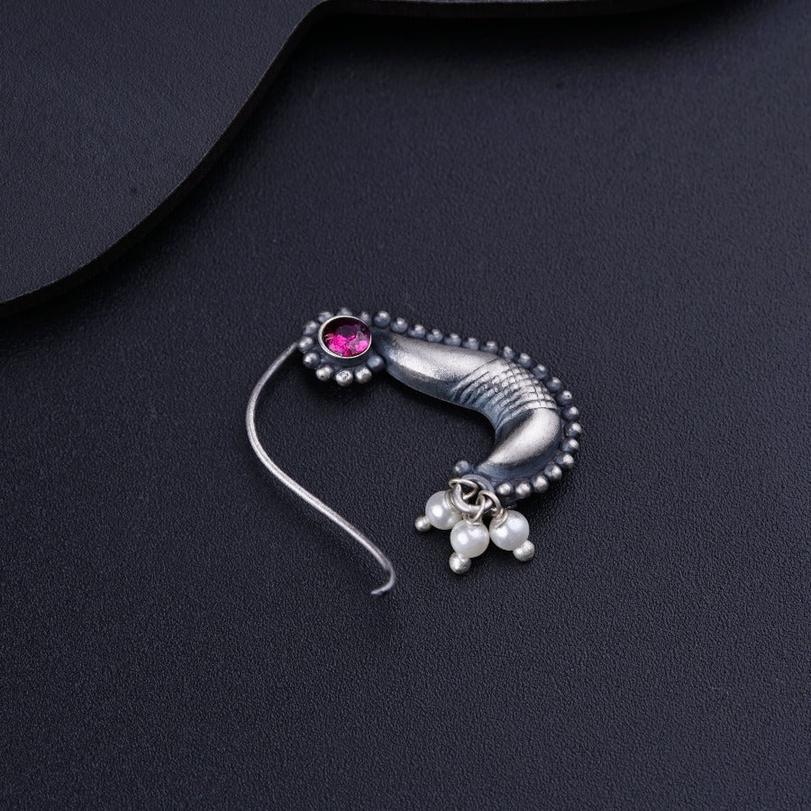a close up of a pair of earrings on a black surface