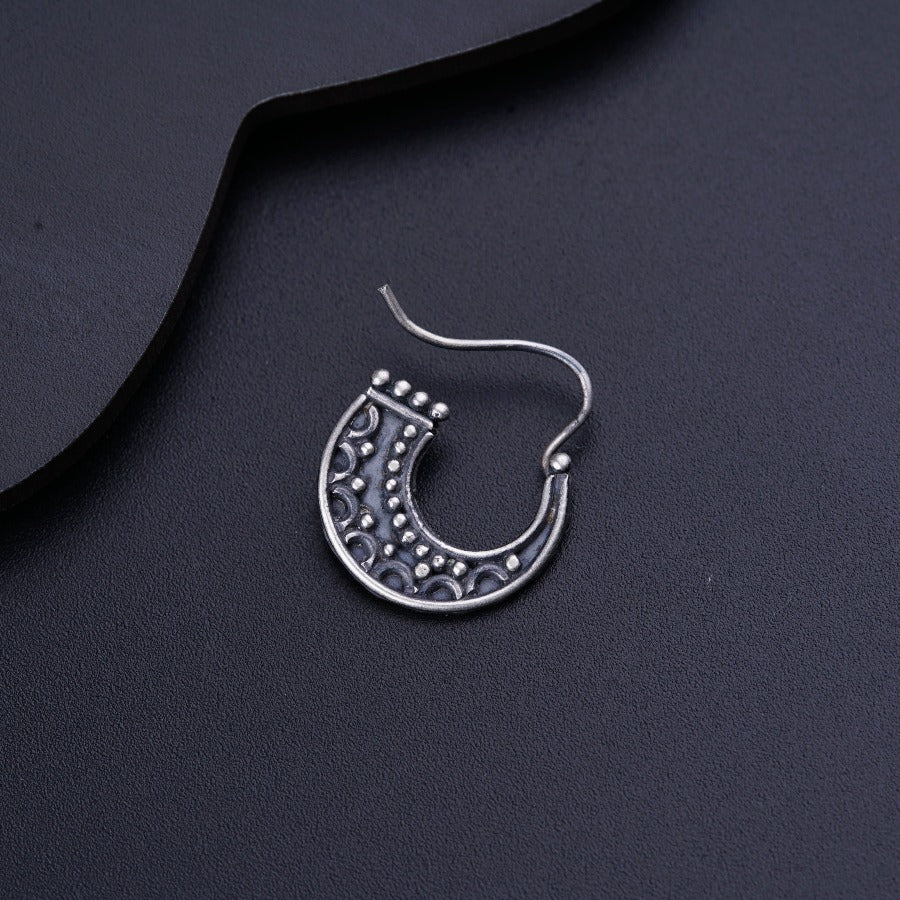 a close up of a pair of earrings on a black surface