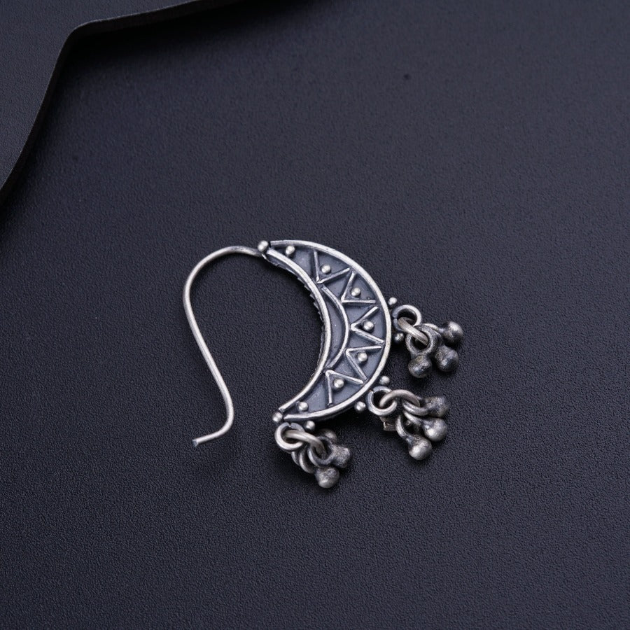 a close up of a pair of earrings on a black surface