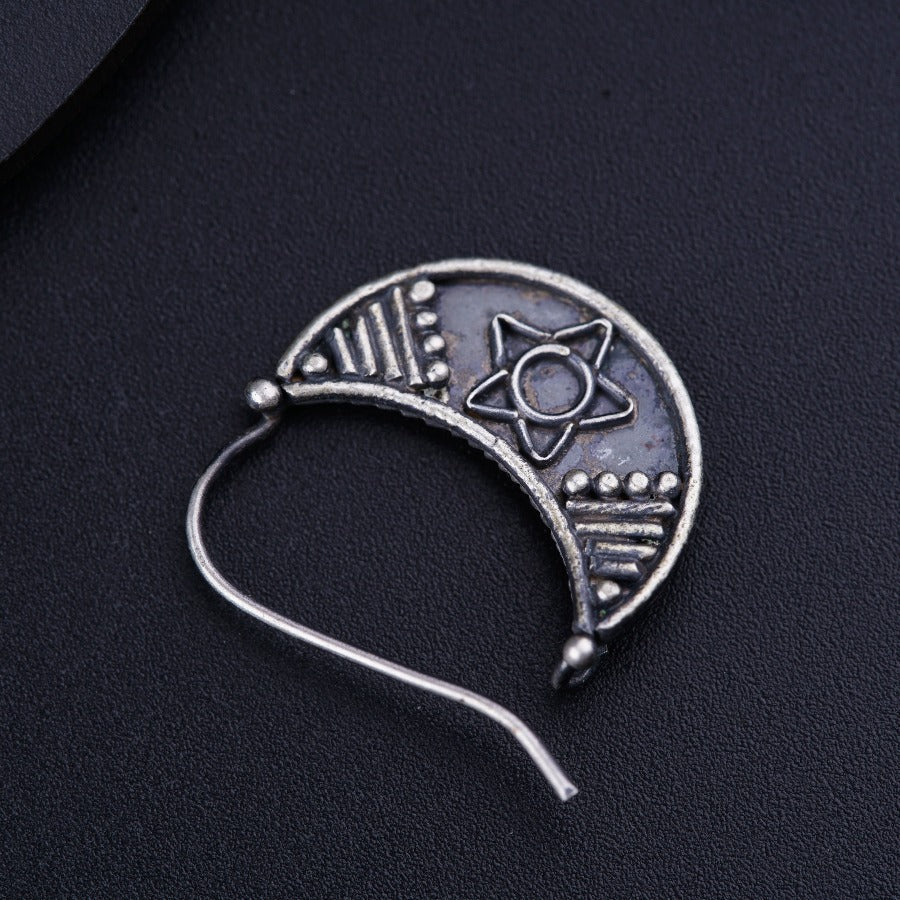a silver brooch with a star and moon on it