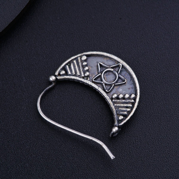 a silver brooch with a star and moon on it