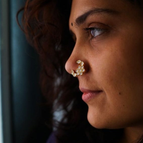 Close-up of floral motif and white stone detailing on gold plated silver nath