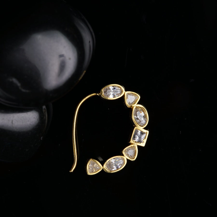 a pair of earrings sitting on top of a black surface