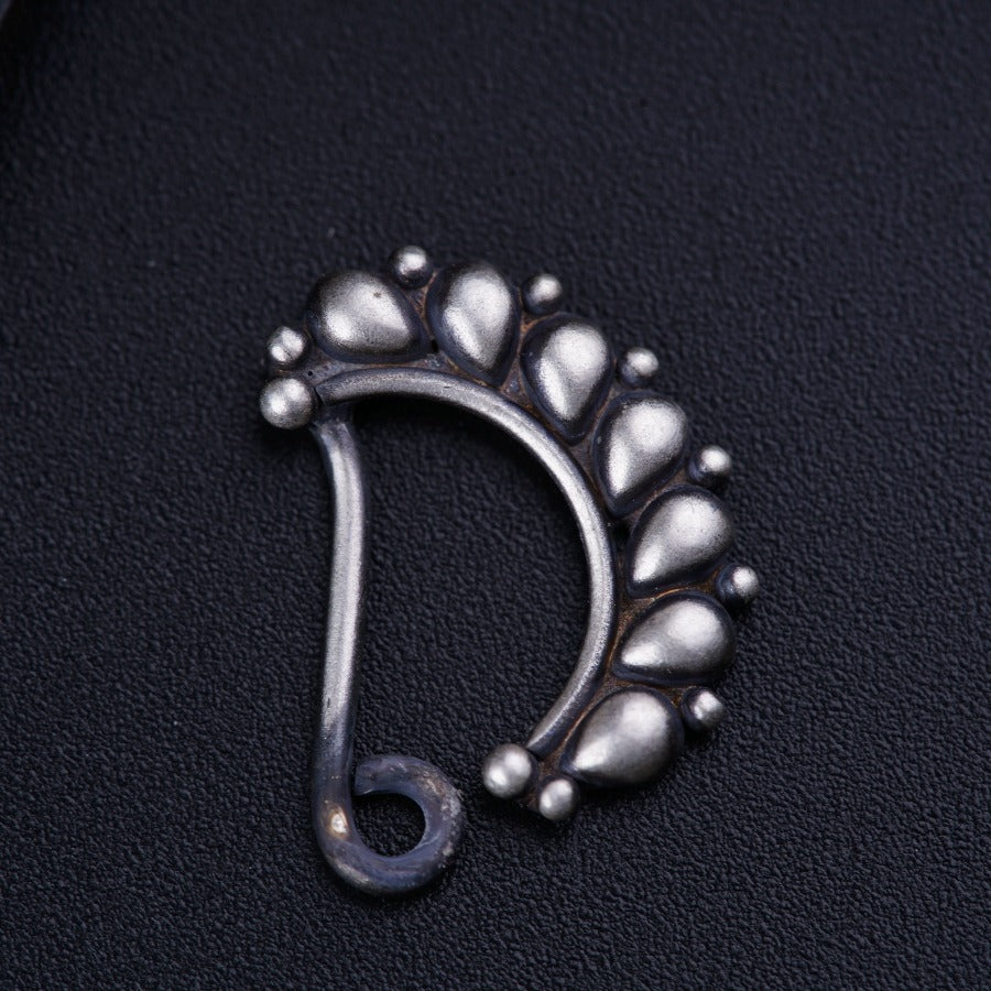 a close up of a metal object on a black surface