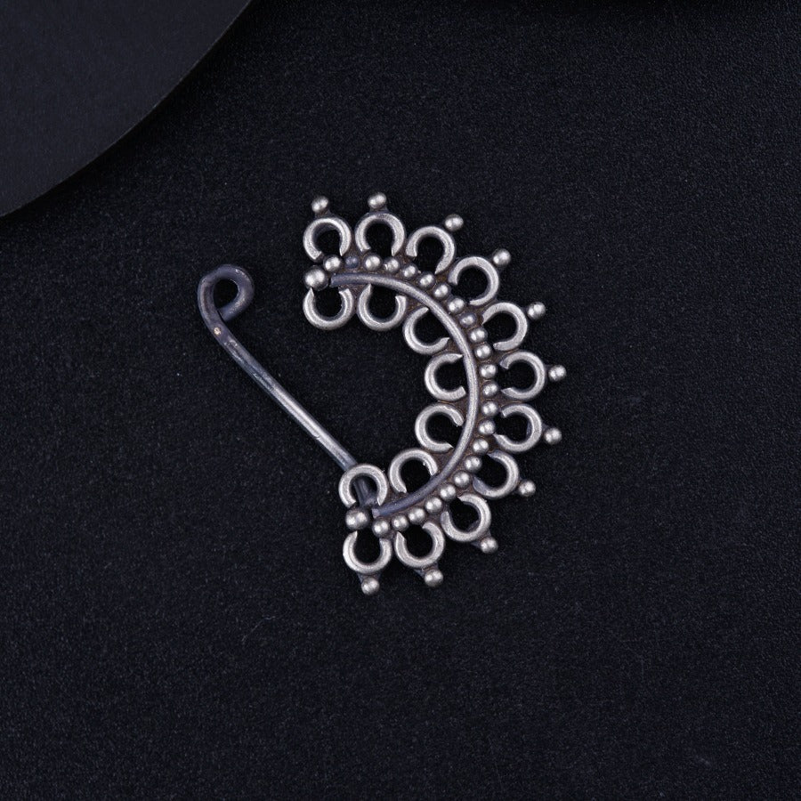 a close up of a brooch on a black surface