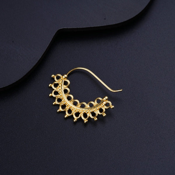 a pair of gold earrings on a black surface