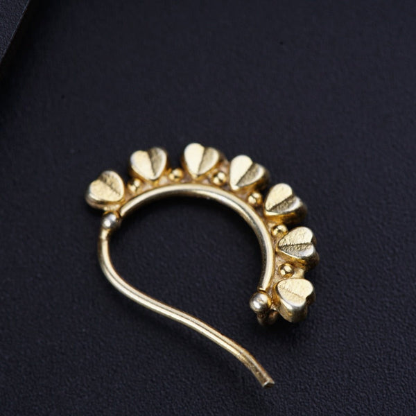 a close up of a gold brooch on a black surface
