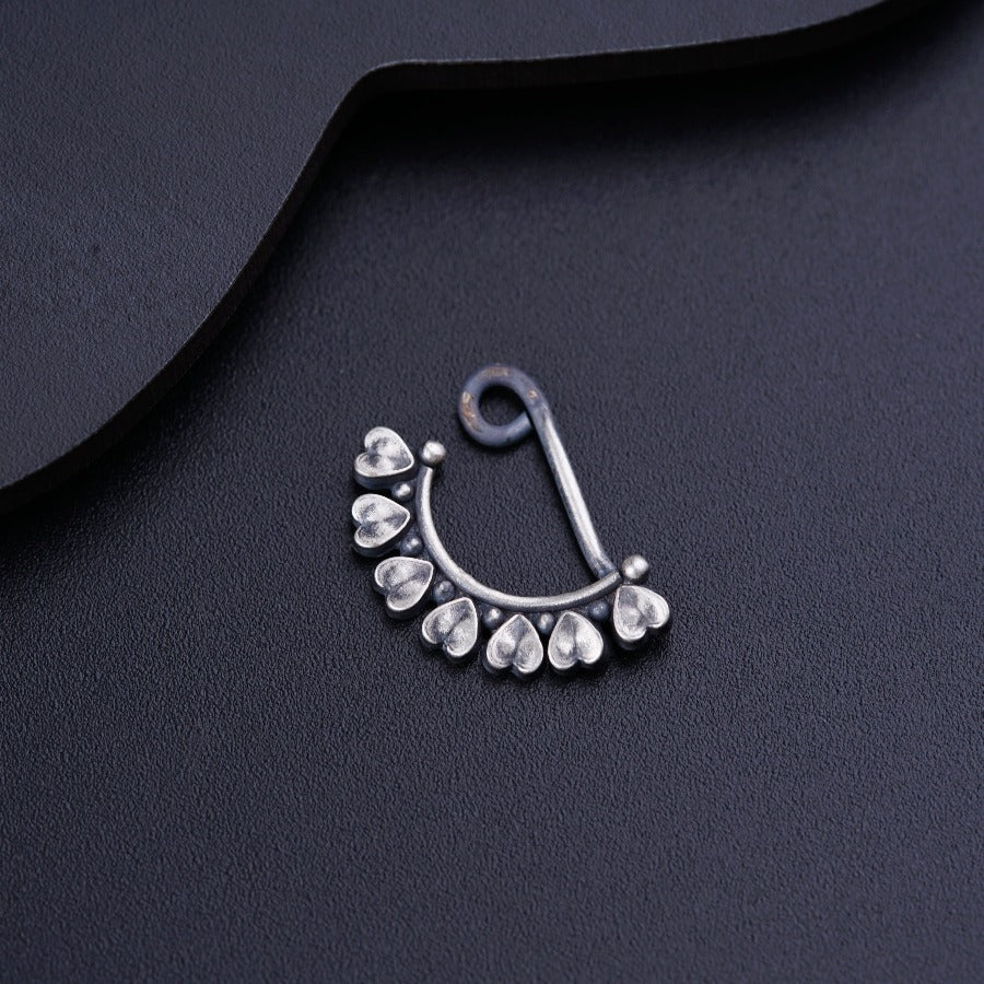 a close up of a nose ring on a black surface