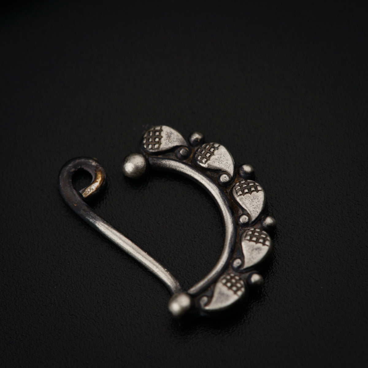 a pair of silver colored metal hooks on a black surface