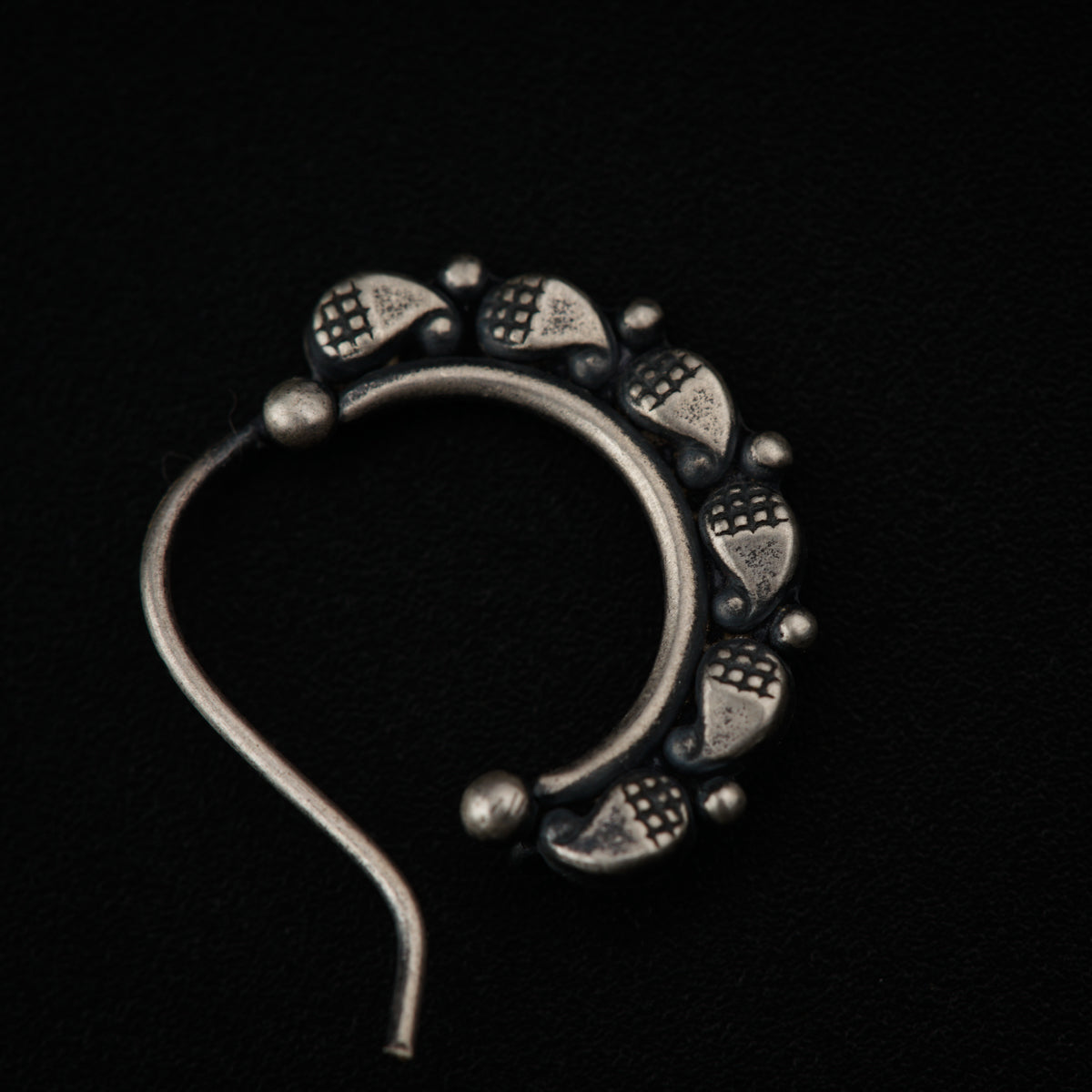 a pair of silver colored ear rings on a black background