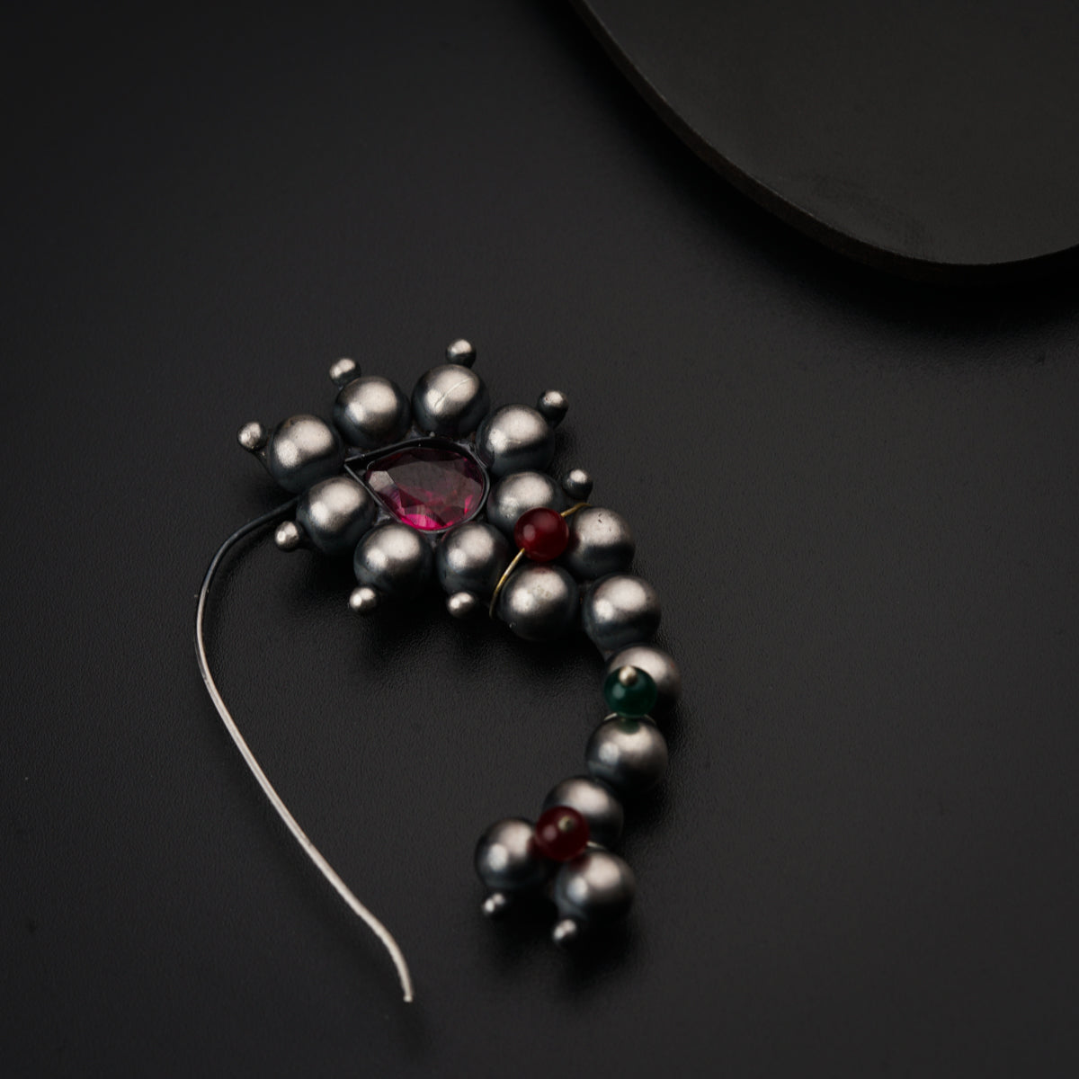 a close up of a beaded object on a black surface