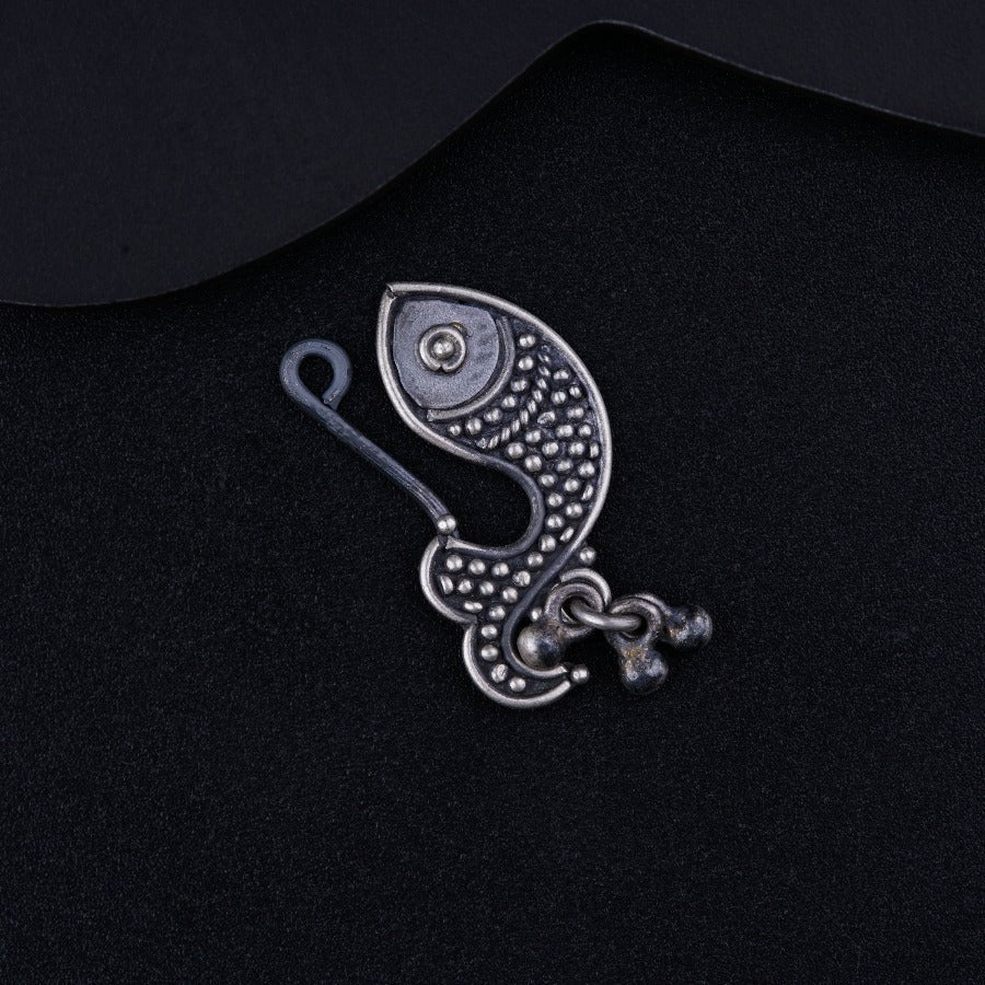 a silver brooch with a fish design on it