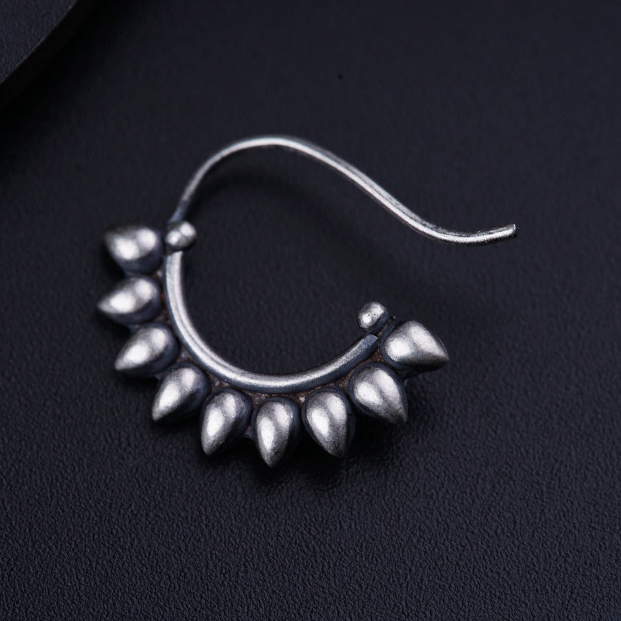 a close up of a pair of earrings on a black surface